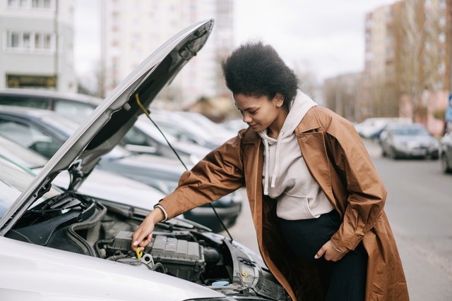 Photo by Ivan Samkov: https://www.pexels.com/photo/a-pregnant-woman-fixing-a-car-engine-7990617/ Do these easy car repairs yourself!